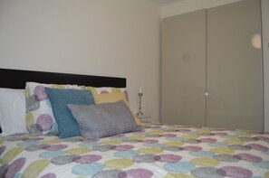 A bed with a polka dot bedspread, a black headboard, and multiple pillows. - Bajamar 152 - Luxury house near the sea (Santa Cruz Tenerife)