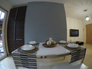 A dining area with a round table, chairs, and a television on the wall. - Bajamar 152 - Luxury house near the sea (Santa Cruz Tenerife)