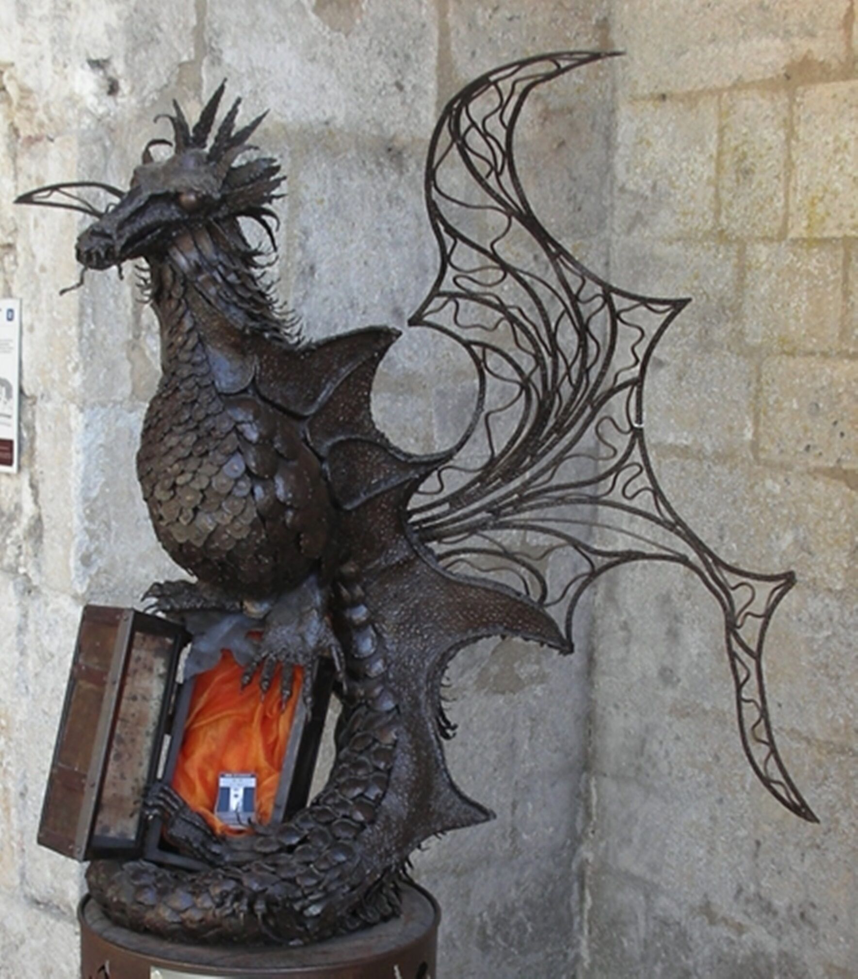 A dragon statue with a shield and a book.