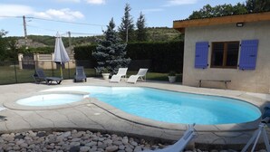A swimming pool with two hot tubs, surrounded by lounge chairs and a pebble bed. - Spacious villa, private, secure swimming pool Jacuzzi on large, enclosed grounds (Sampzon)