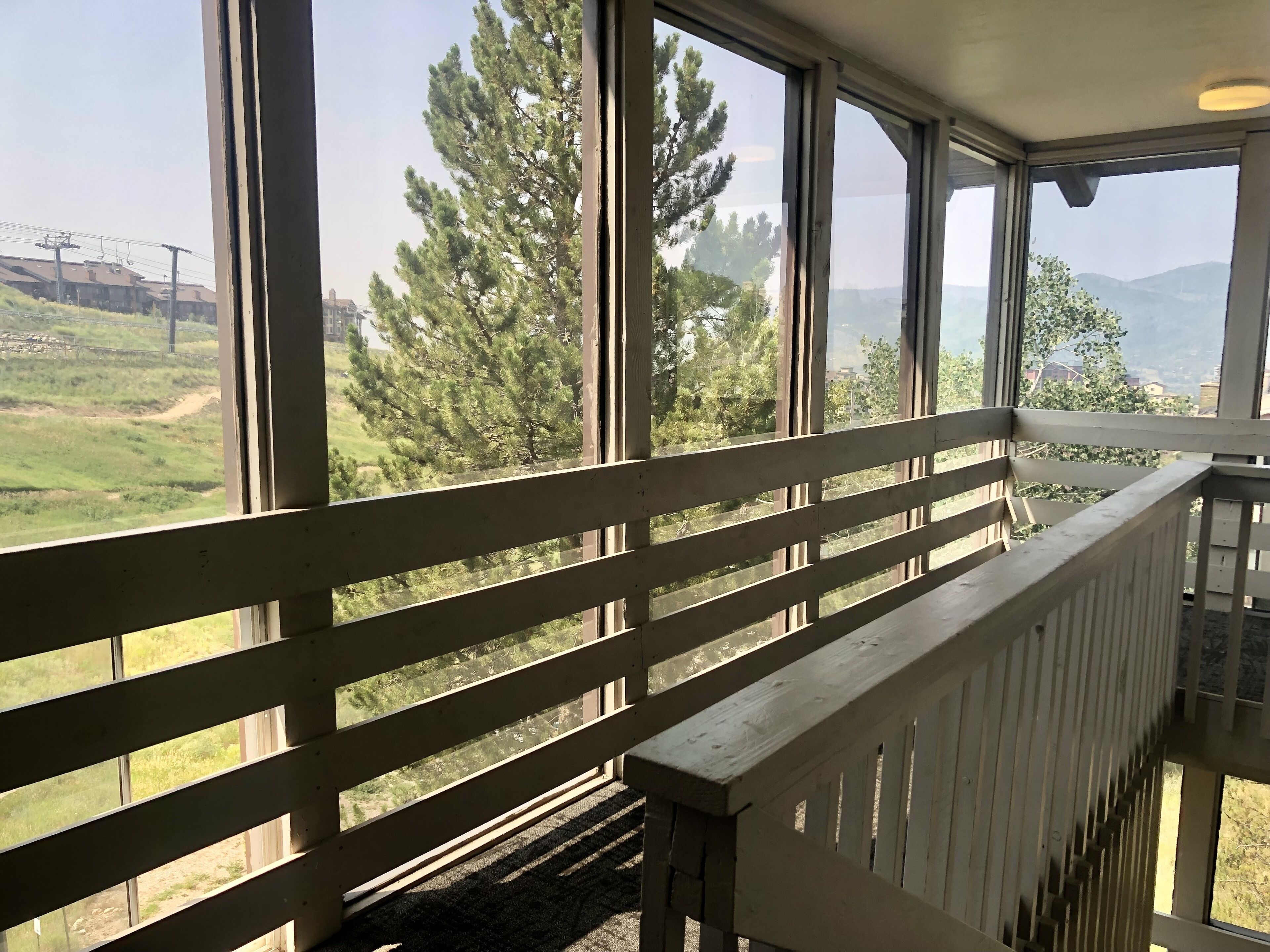 Habitación con ventanas amplias que ofrecen vistas a un paisaje verde y árboles.
