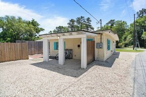 A single-story house with a covered porch and a gravel driveway. - Beach Cottage -optional BIKES - Walk 2 Shops & Fun (Saint Simons Island)