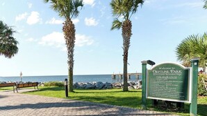 A welcome sign at Neptune Park with a view of the ocean and a pier. - Beach Cottage -optional BIKES - Walk 2 Shops & Fun (Saint Simons Island)