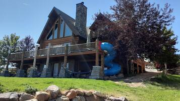 Guests can enjoy a balcony with a railing overlooking a well-maintained lawn and a stone wall.