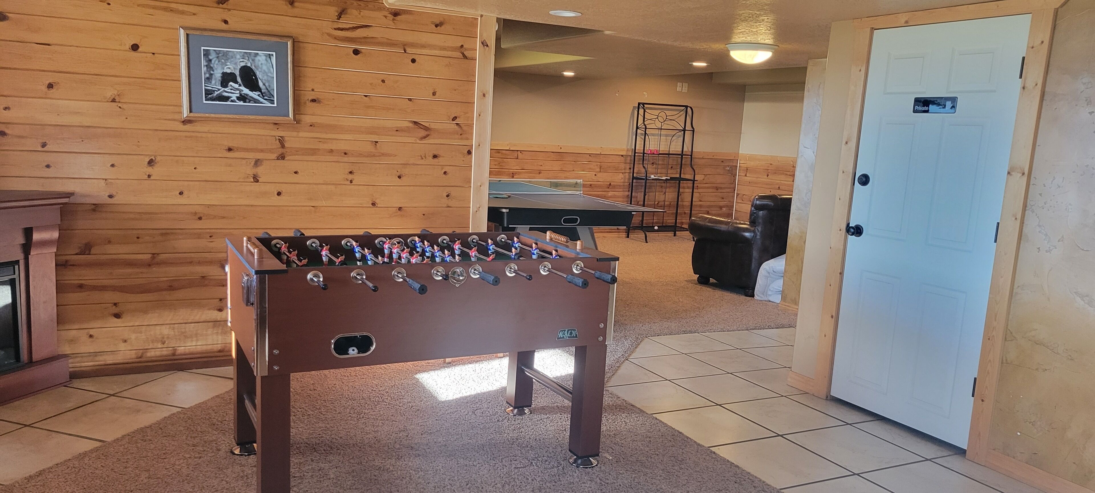 A room with a foosball table, a ping pong table, and a door labeled "Private."