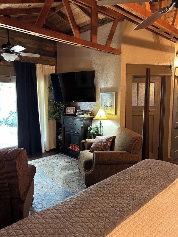 Una habitación acogedora con chimenea, televisor y un rincón de estar confortable.