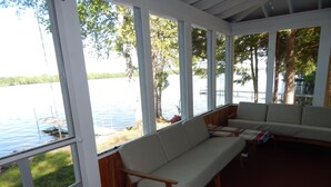 A covered outdoor seating area with a view of a lake and dock. - 10 Steps And You're  In Sebasticook Lake. This Is Where You Go To Unplug (Newport)