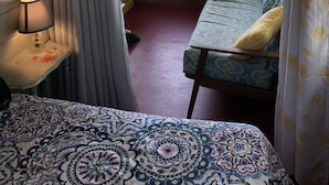 A cabin room with a bed, a small table with a lamp, and a view of a lake through large windows. - 10 Steps And You're  In Sebasticook Lake. This Is Where You Go To Unplug (Newport)