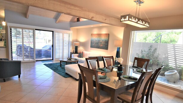 A spacious dining area with a large table and chairs, a sofa, and a coffee table in the background.