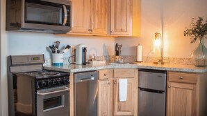 Une cuisine moderne dotée d’appareils électroménagers en acier inoxydable, d’armoires en bois et d’un plan de travail en granit.