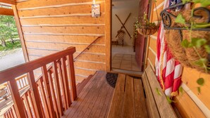 A wooden cabin with a wooden staircase leading to a door, a welcome sign, and an American flag. - Ski Town Condos - Mountain Comfort in Monarch/Garfield, Colorado (Salida)