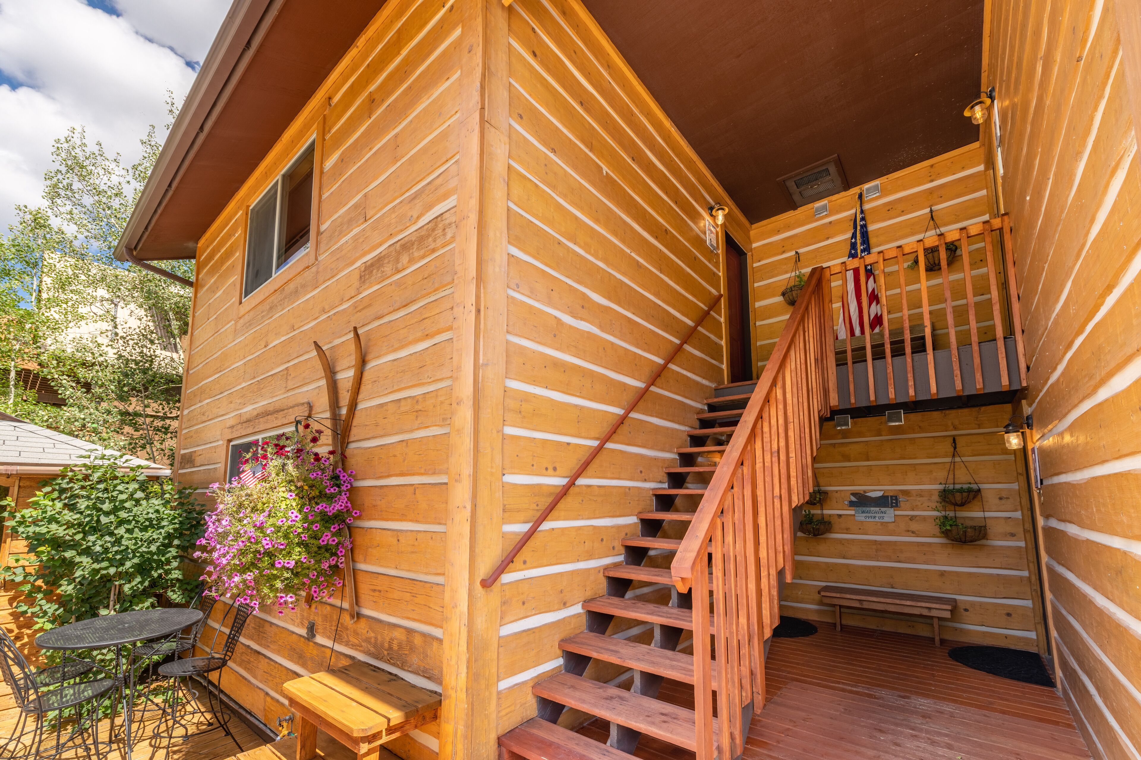 Une cabane en bois avec un escalier en bois menant à une terrasse.