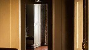 A hallway with a wooden floor, a chair, and a door leading to another room. - Numa Florence  Palazzo San Niccolò (Florence)