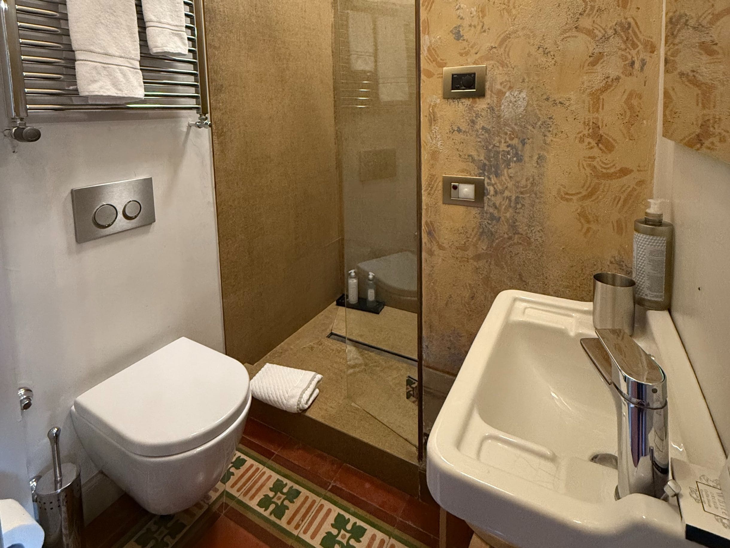 Une salle de bain comprenant des toilettes, un lavabo et un espace douche.