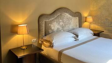 A neatly made bed with white linens, two bedside lamps, and a textured headboard.