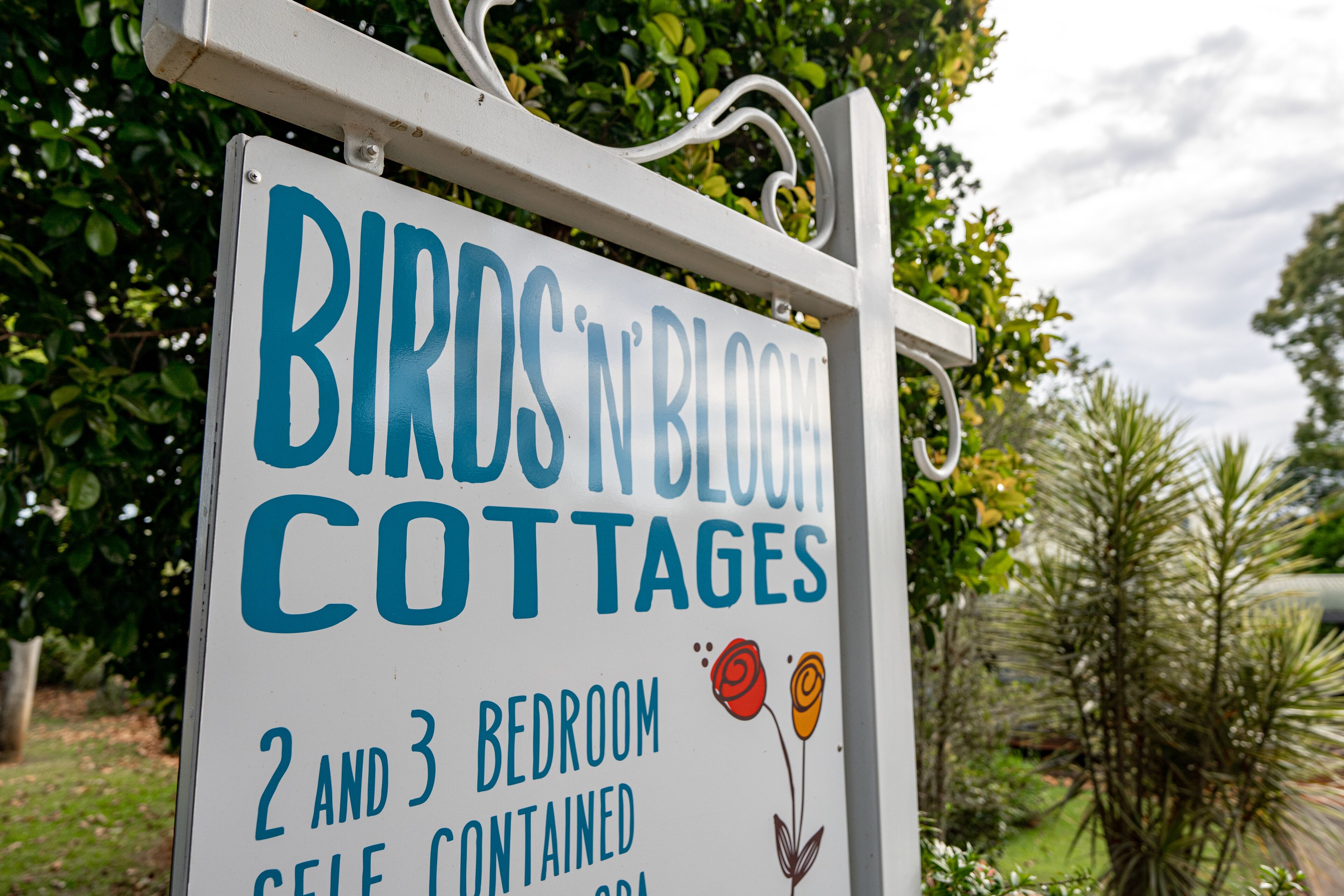 Segnaletica per 'Birds N' Bloom Cottages' che indica cottage indipendenti con 2 o 3 camere da letto.