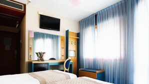 A hotel room with two beds, a desk, a TV, and a bathroom. - Hotel Monaco & Quisisana (Jesolo)