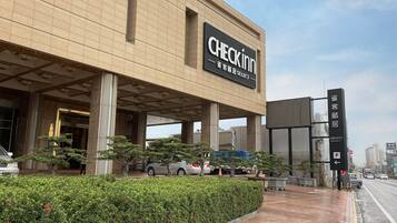 A modern building with a large sign reading "CHECKIN SELECT" indicating a hotel or motel.