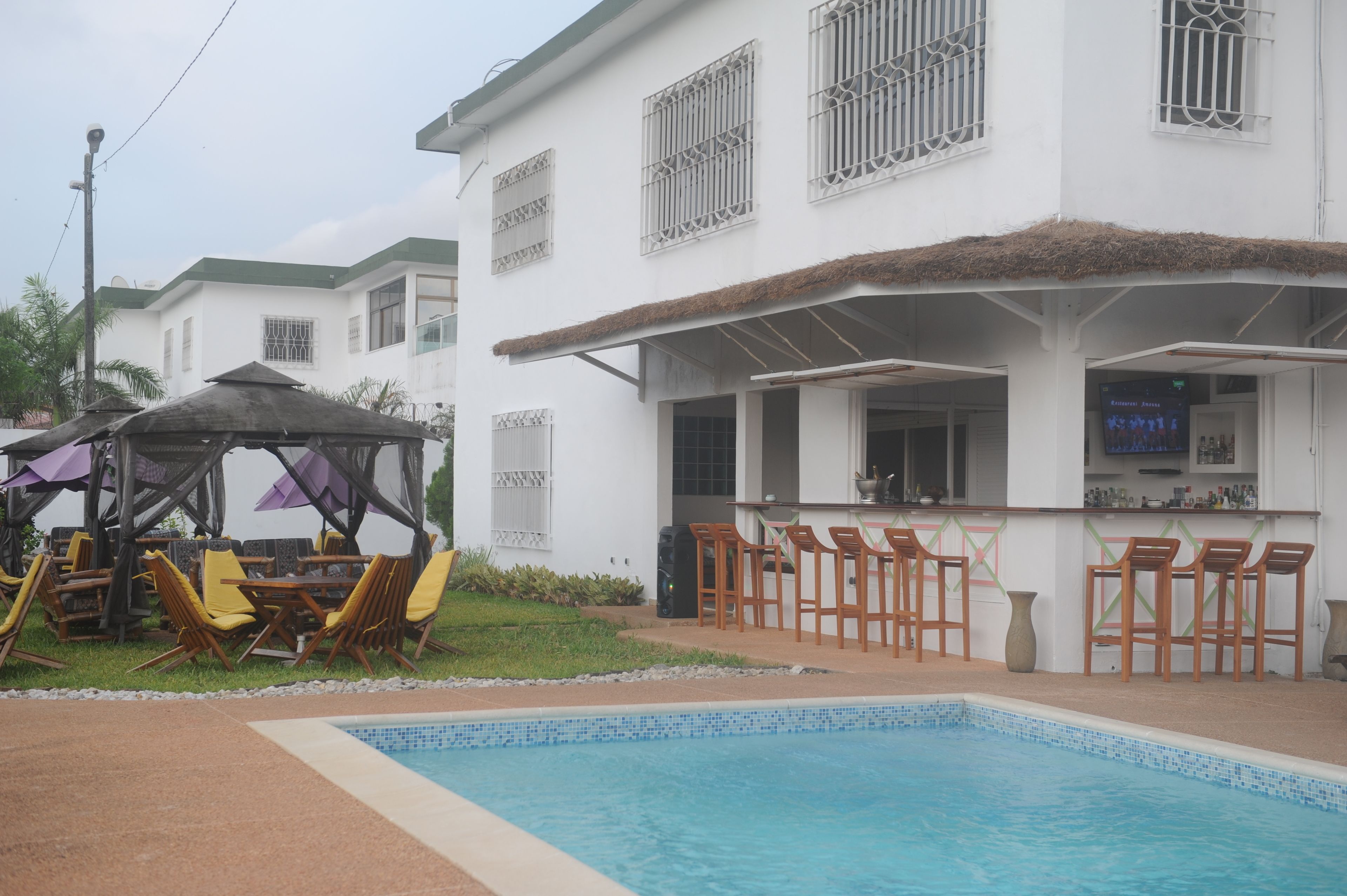 Een buitenzwembad, parasols bij het zwembad en ligstoelen
