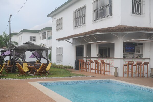 Utomhuspool, parasoller och solstolar