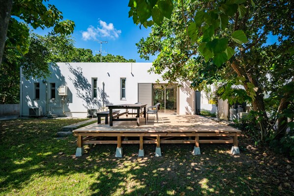 A modern house with a patio, a dining table, and chairs.
