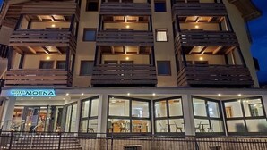 A multi-story hotel with balconies and a restaurant at the ground level. - Hotel Moena (Moena)