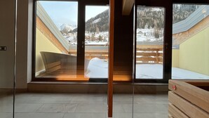 A modern interior with large windows offering views of a snowy landscape. - Hotel Moena (Moena)
