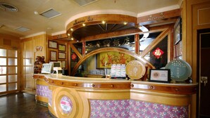 Een receptiebalie met een gebogen vorm, ingelijste certificaten en een traditioneel Chinees decoratief element.