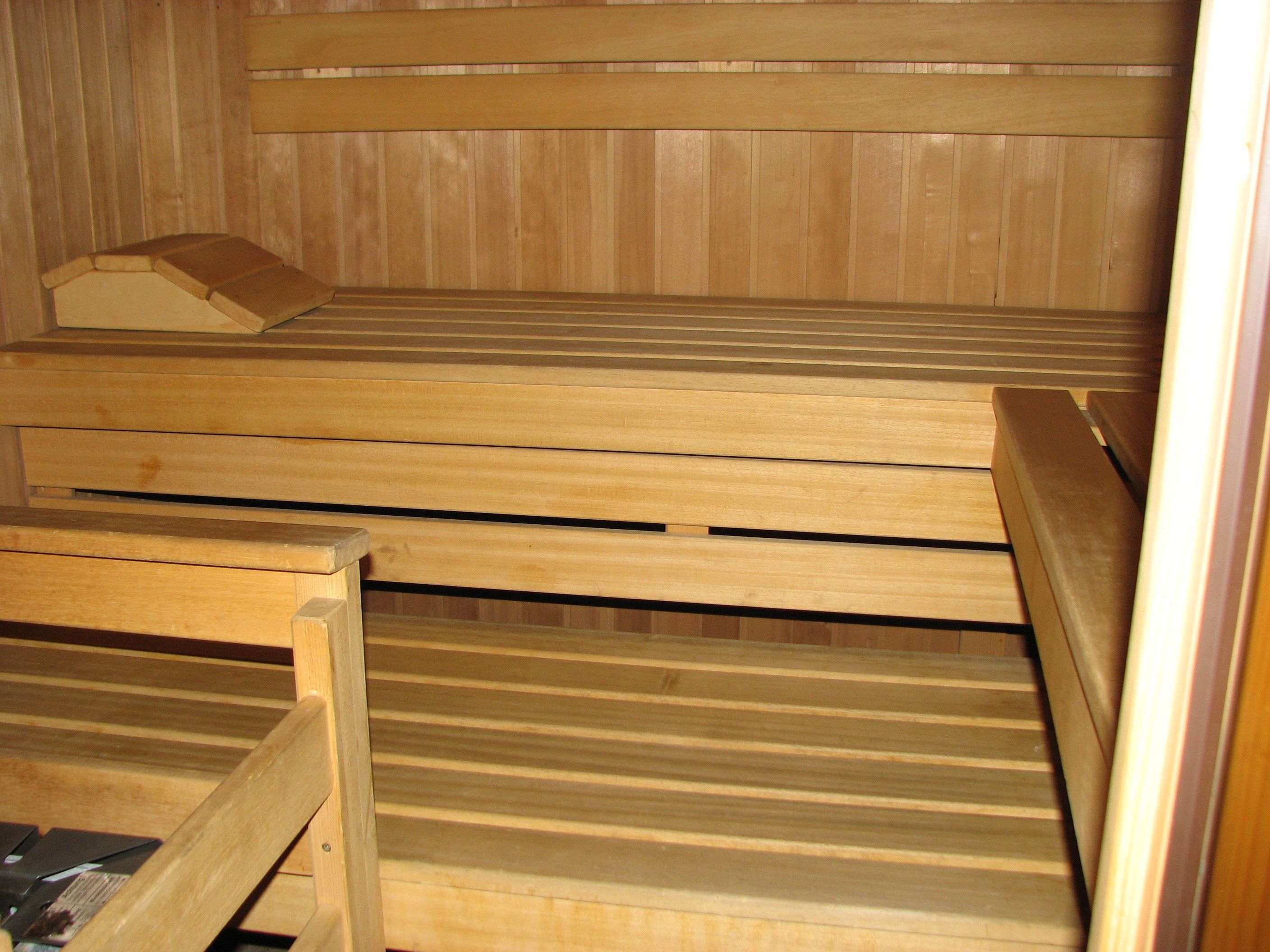 Una sauna con bancos de madera y un asiento.