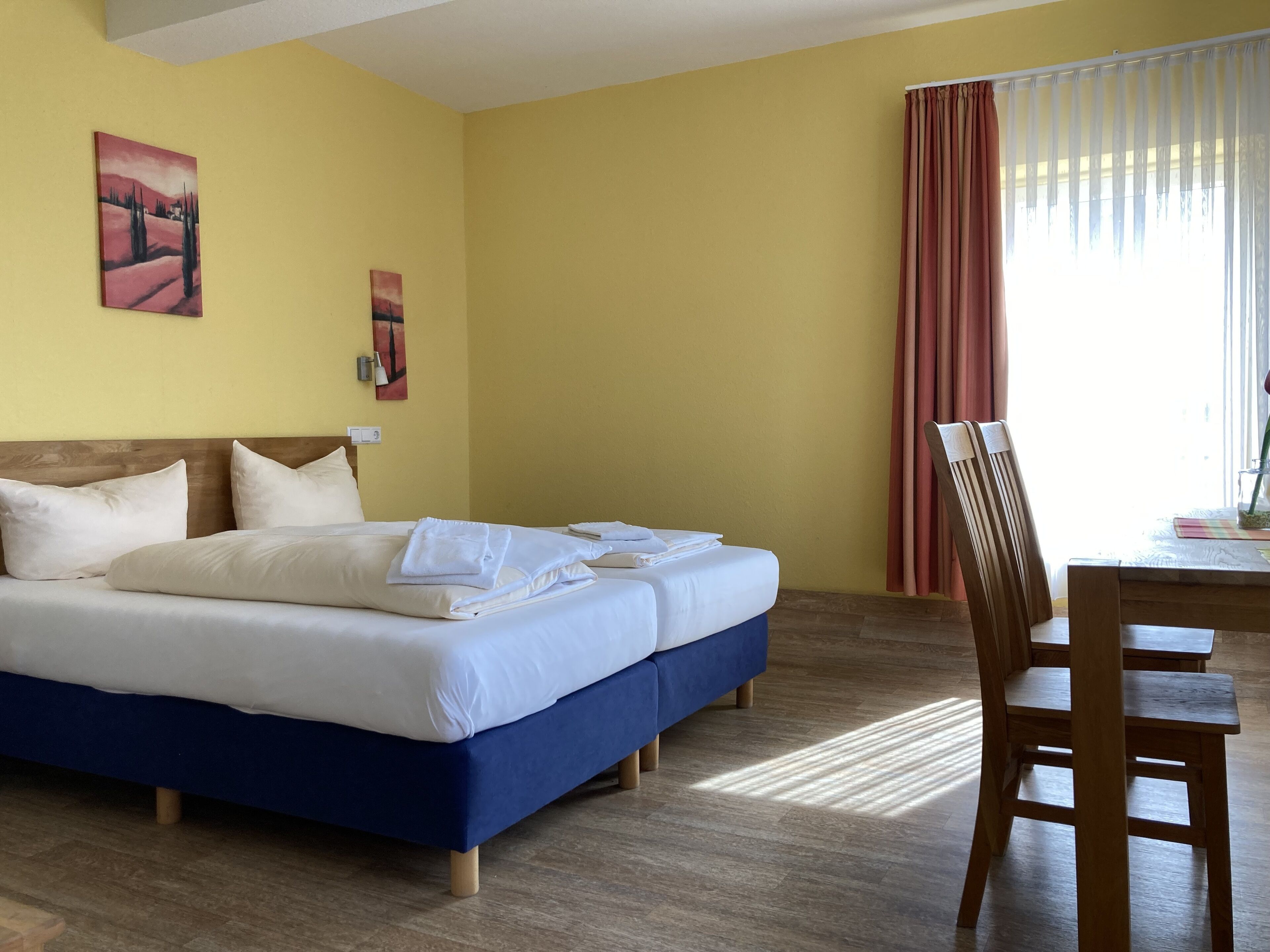 Een hotelkamer met een bed, een bureau en stoelen.