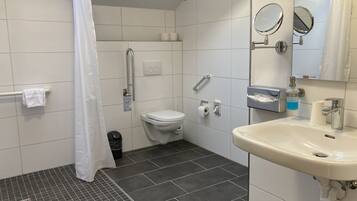 Une salle de bain avec des toilettes, un lavabo et un rideau de douche.