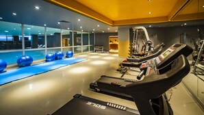 Un gimnasio moderno con equipo de ejercicio, una cinta de correr y pelotas de ejercicio azules.