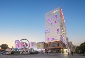 A modern hotel with a prominent sign, a large digital display, and a well-lit entrance area. - MiniMax Hotel Shanghai Songjiang (Shanghai)