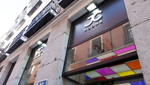 Fachada de hotel con un letrero que dice 'ROOMS' y un cartel azul de accesibilidad para personas con discapacidad.