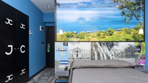 A hotel room with a large window offering a scenic view of a lake and mountains. - Hotel JC Rooms Chueca (Madrid)