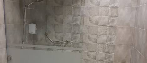 Ein modernes Badezimmer mit einer Glasdusche, einer Toilette und einem Waschbecken.
