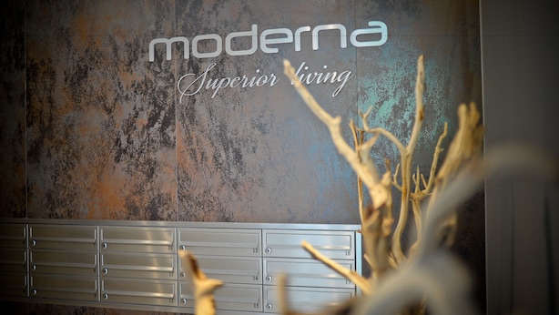 A wall with the text "moderna Superior living" and a metal locker with numbers 10-17. - Grand Apartments Victoria Residence (Sopot)