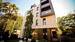 A modern building with multiple floors, large windows, and a sign advertising 92 m² and 100 m² residential spaces. - Grand Apartments Victoria Residence (Sopot)