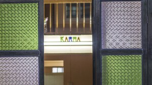 A hotel entrance with a glass door featuring a geometric pattern. - Karma Home Hostel (Phitsanulok)