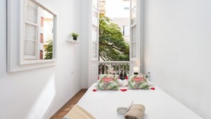 A narrow room with a bed, a window, and a view of a tree. - Pensión Casablanca (Santa Cruz de Tenerife)