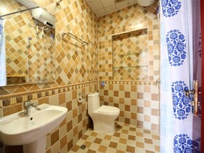 Un baño con suelo de baldosas a cuadros, un lavabo, un inodoro y una zona de ducha.