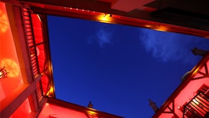A building with a red-lit balcony and a clear blue sky. - Qingdao Wheat Youth Hostel (Qingdao)