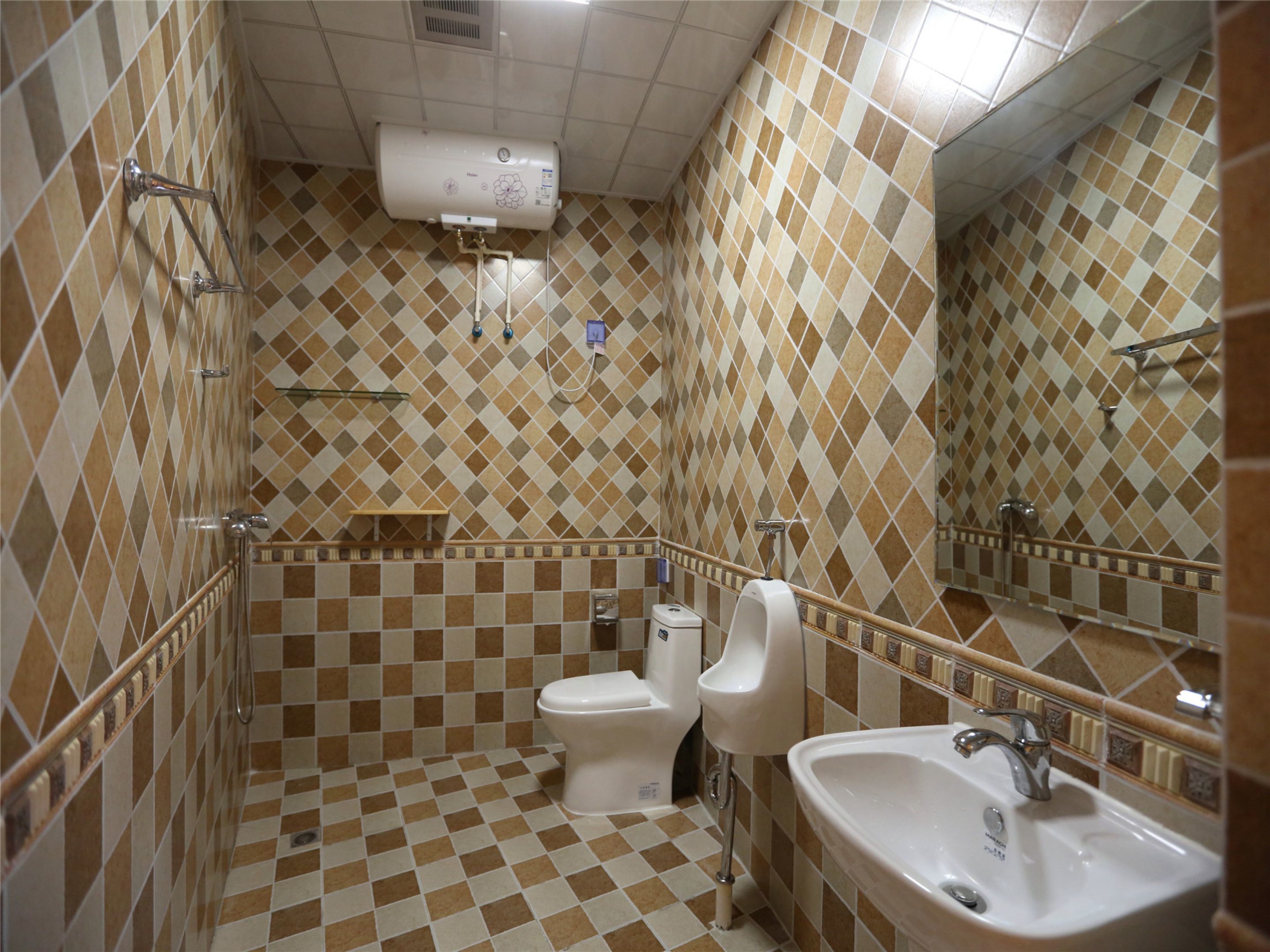 Een badkamer met een zwart-wit schakeerdmotief vloer, een toilet, urinoir, wastafel en een handdoekhouder.
