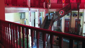 A multi-level building with a wooden staircase and balconies. - Qingdao Wheat Youth Hostel (Qingdao)