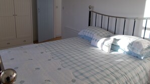 A bedroom with a bed, a wardrobe, and a door. - Bluebell Bank (Dumfries)