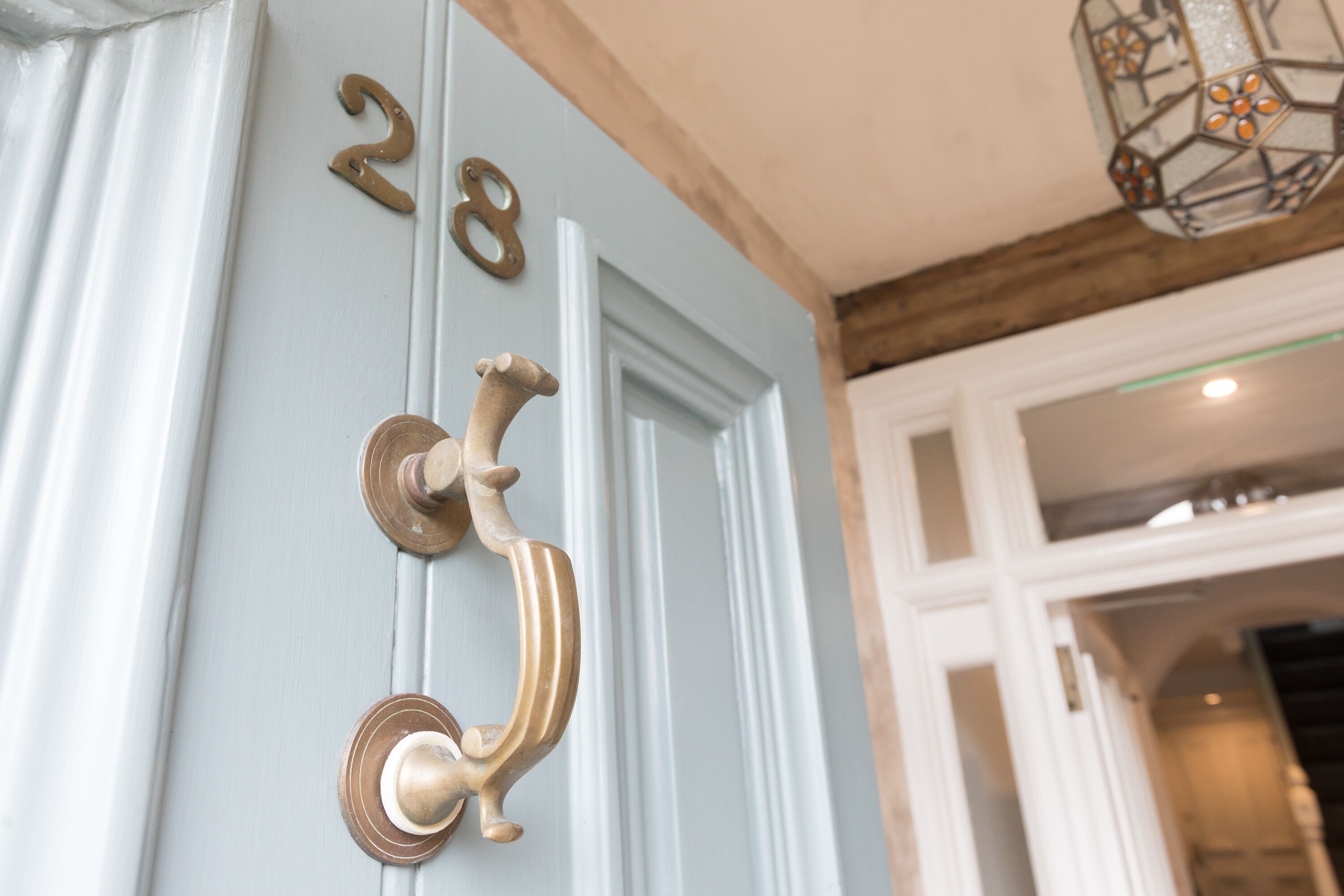 A door with a brass handle and the numbers "28" above it.