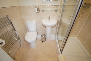 A bathroom with a toilet, sink, and shower. - Abbey Guest House (York)