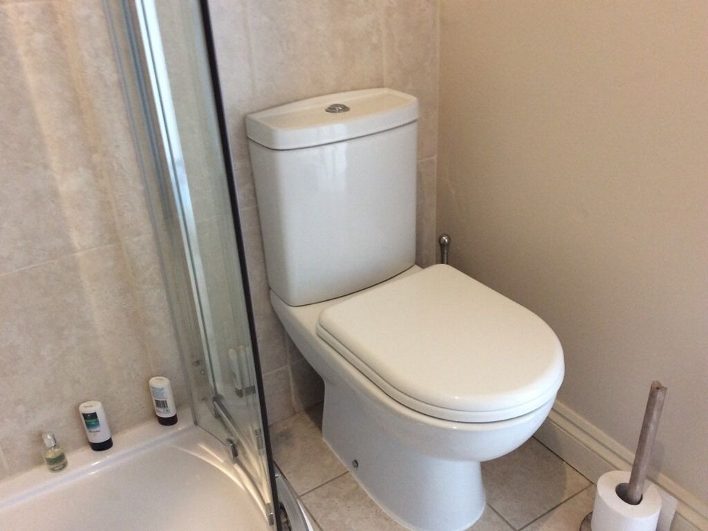 A bathroom with a toilet, a glass shower enclosure, and a bathtub.