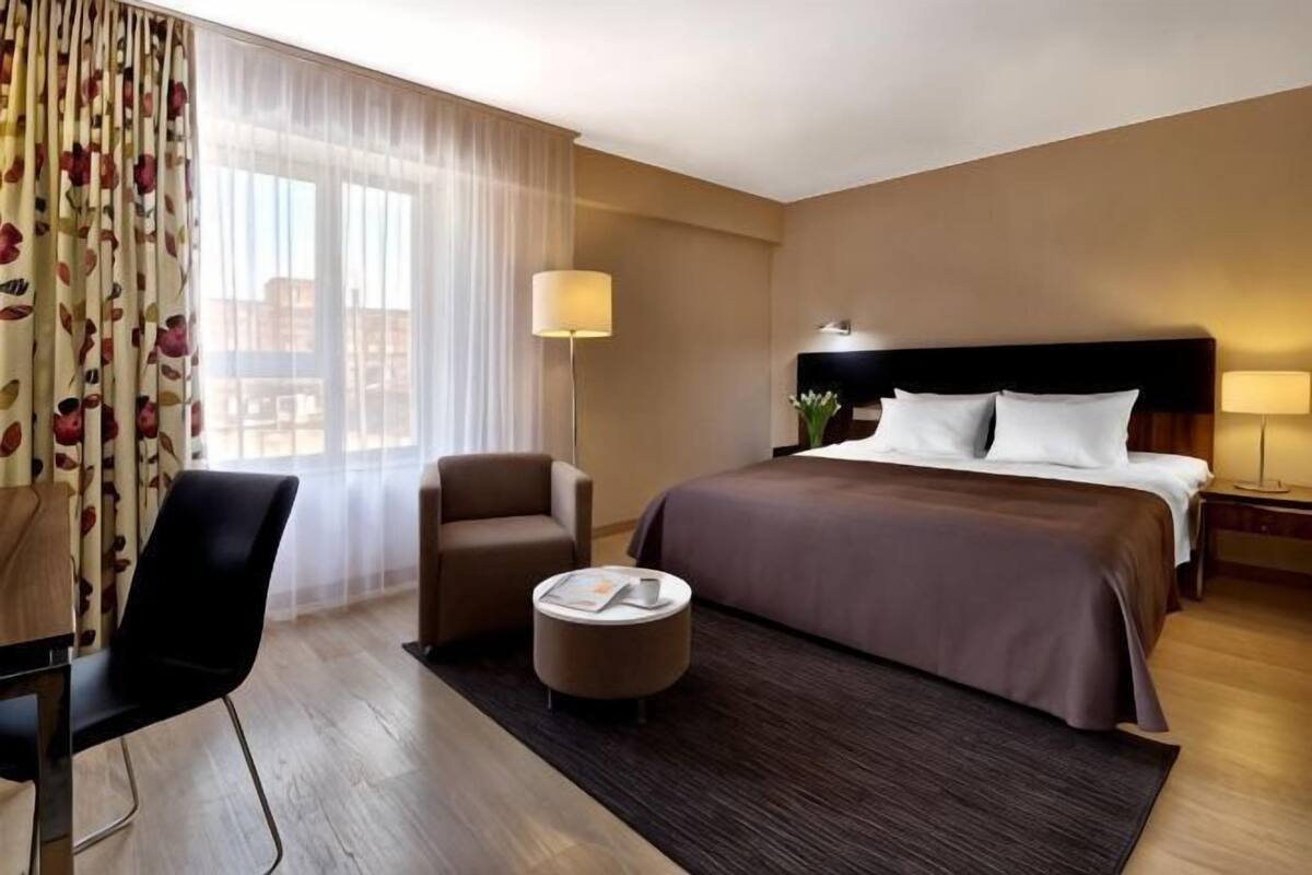 Escritorio, cortinas blackout y tabla de planchar con plancha