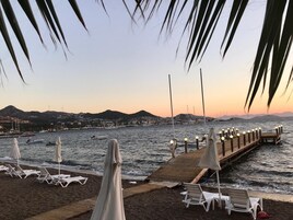 Playa privada, sillas reclinables de playa, sombrillas